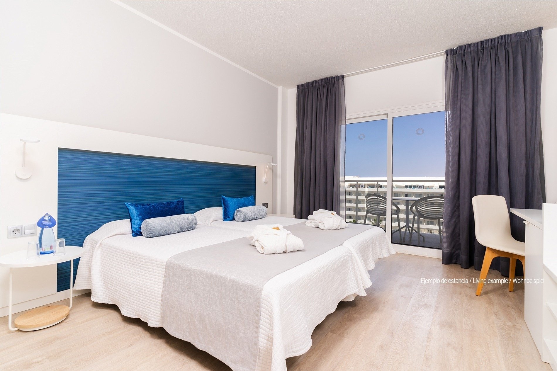 a hotel room with two beds and a blue headboard