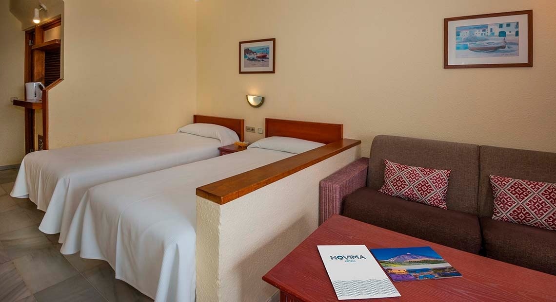 una habitación de hotel con dos camas y un sofá