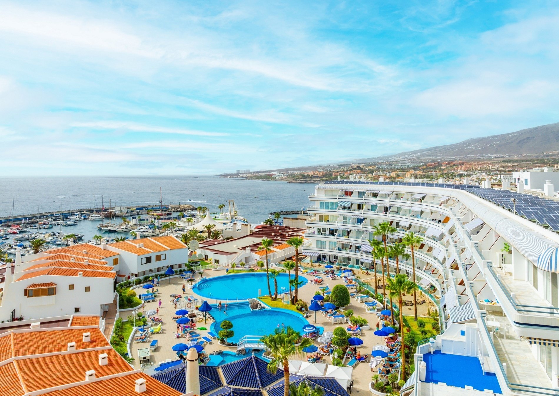 una grande piscina circondata da ombrelloni e sedie in un resort