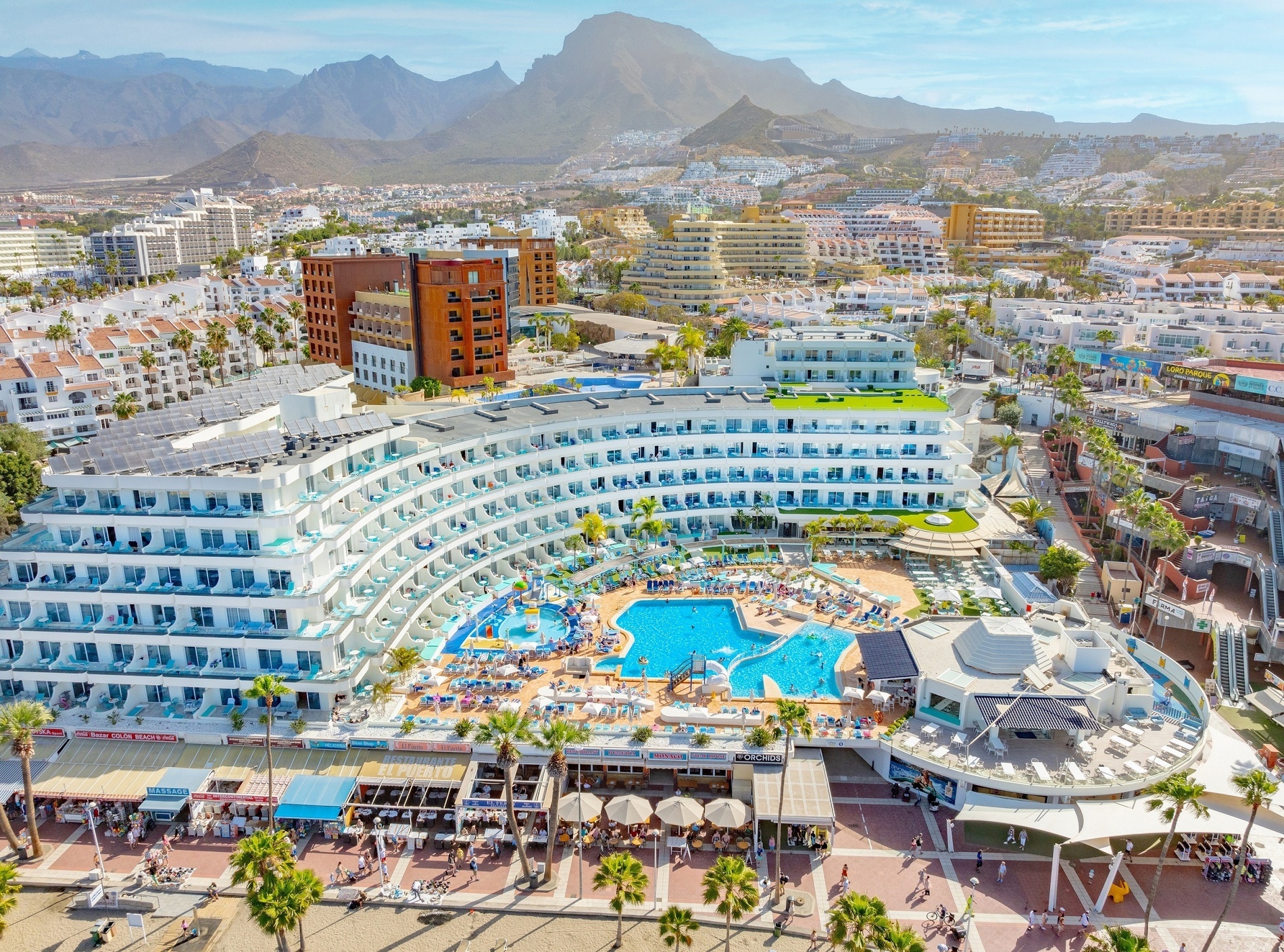 una grande piscina circondata da sedie e ombrelloni in un resort