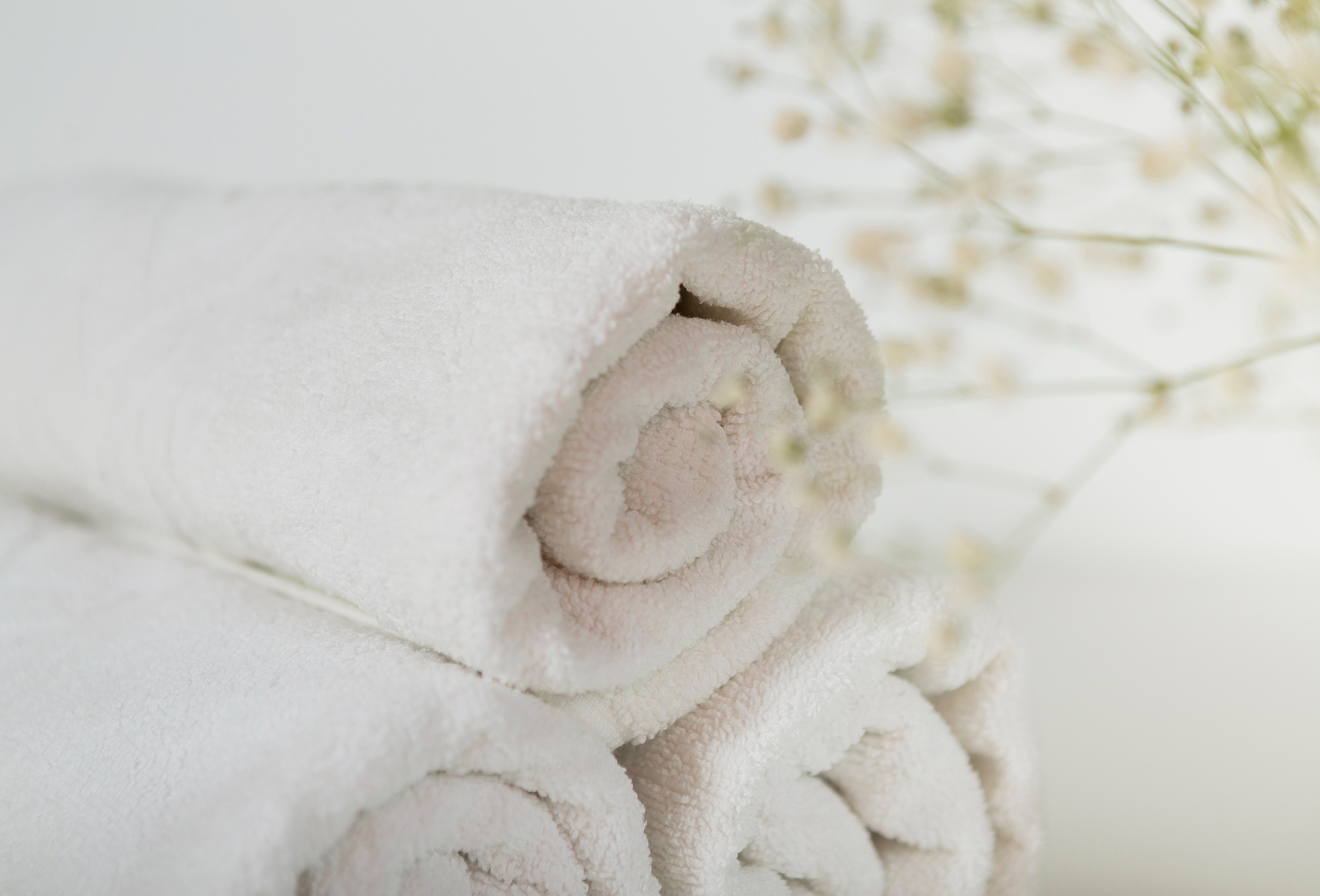 
                                    a stack of white towels with a flower in the background