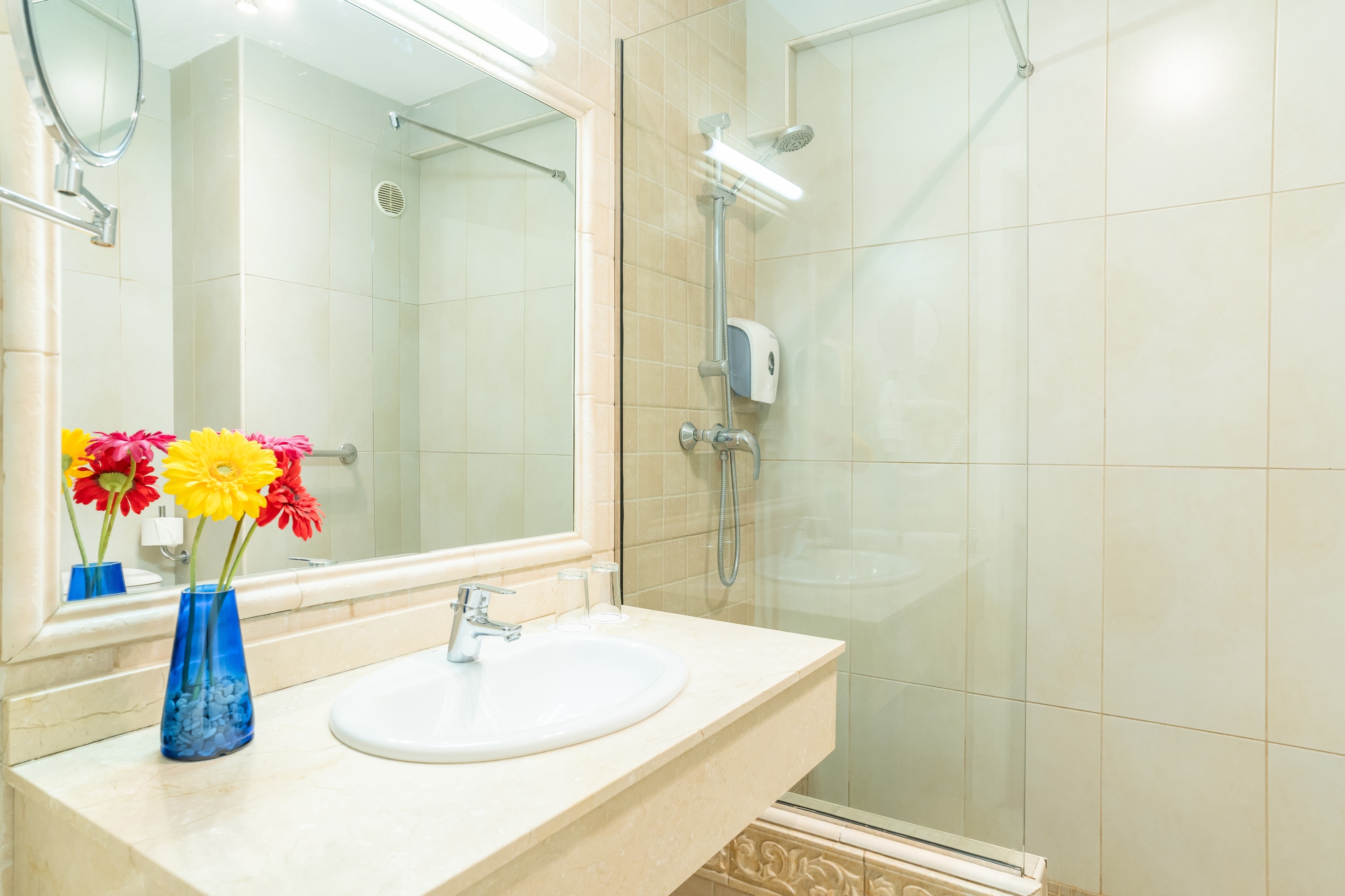 un baño con un lavabo y un jarrón de flores