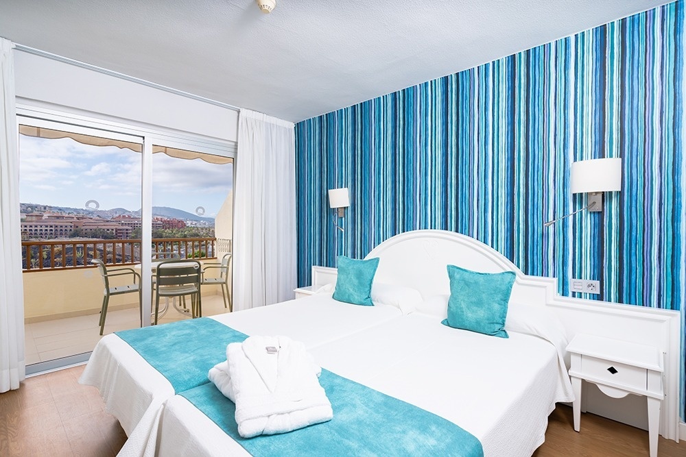 una habitación de hotel con dos camas y almohadas verdes