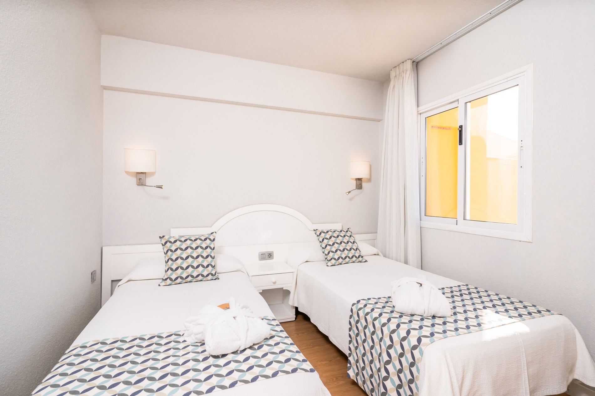 una habitación de hotel con dos camas y almohadas verdes