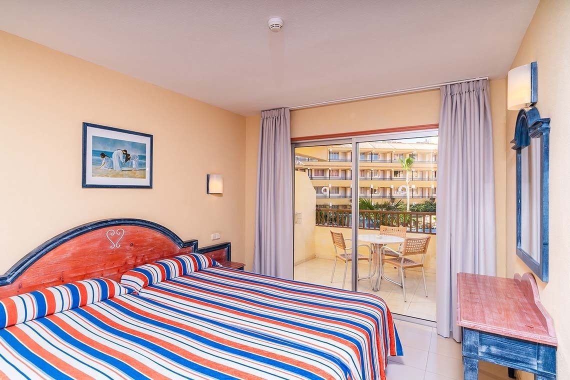 una habitación de hotel con una cama y una mesa y sillas