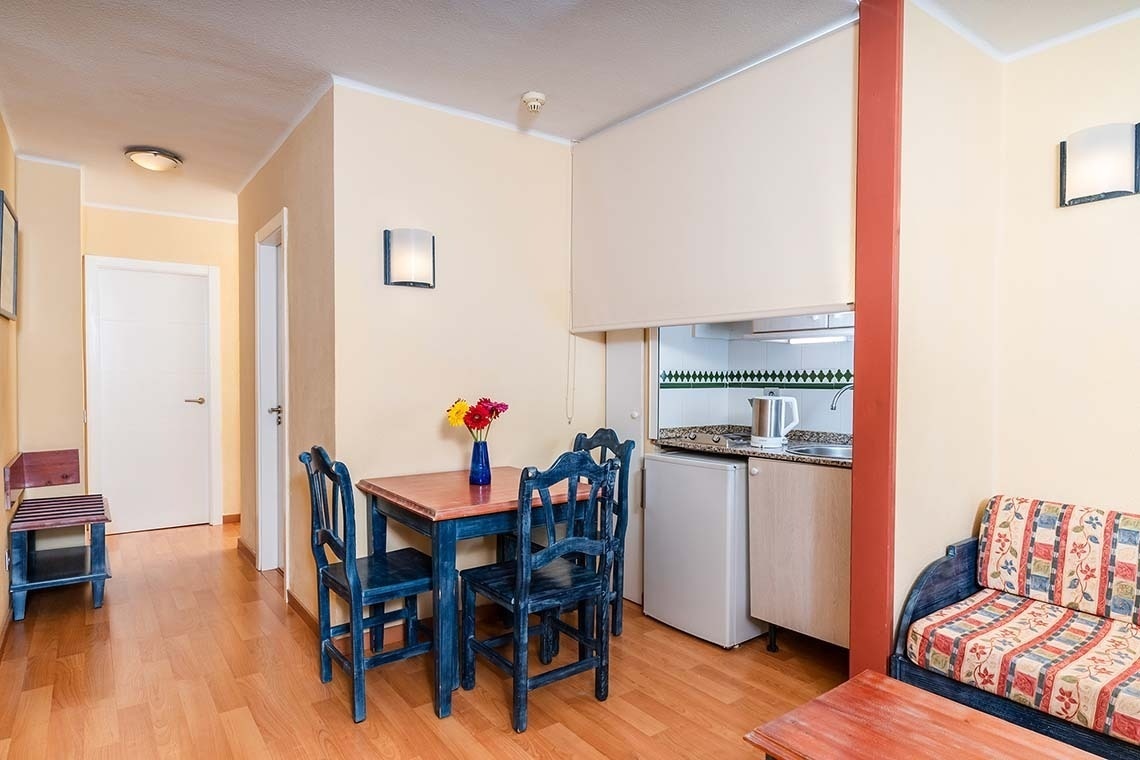 una habitación de hotel con dos camas y una mesa y sillas