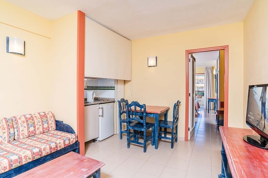 una habitación con una mesa y sillas y una televisión