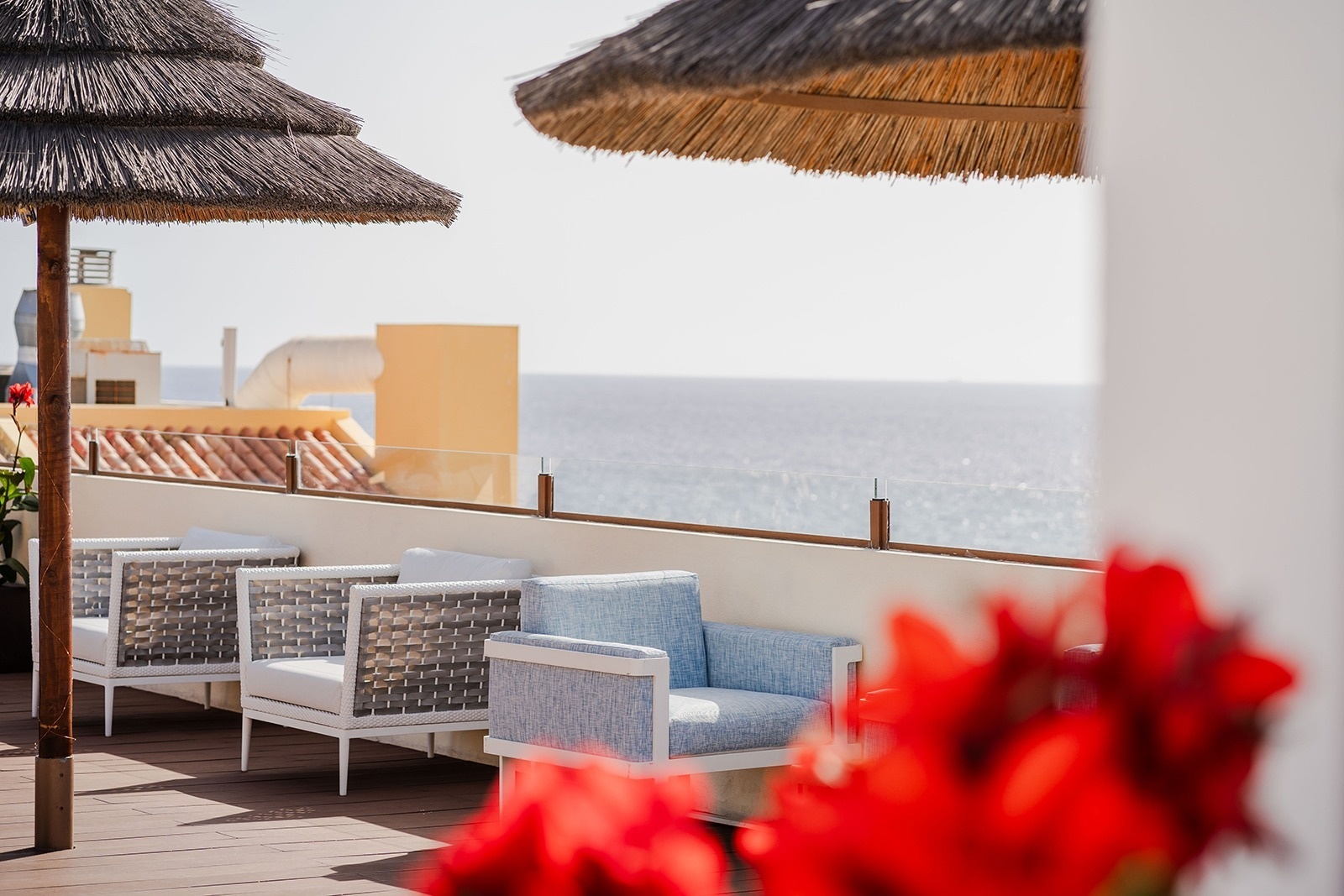 
                                    ein Deck mit Stühlen und Strohschirmen mit Blick auf das Meer