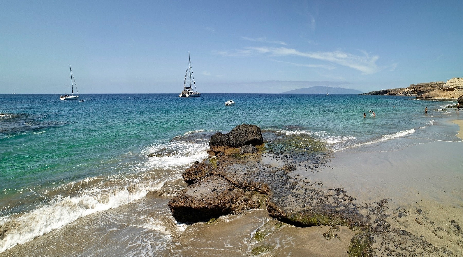 una spiaggia piena di lettini blu e ombrelloni