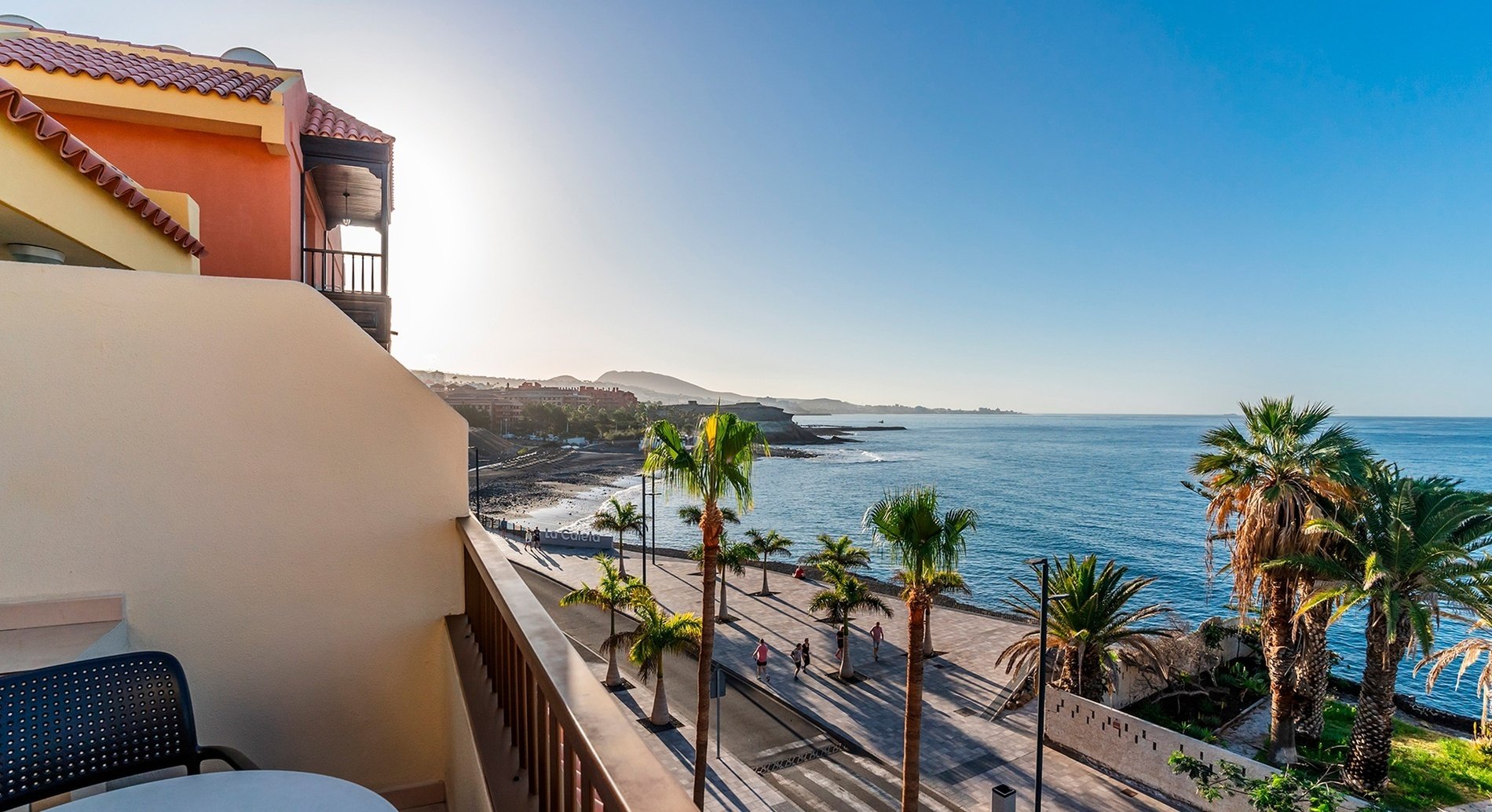 una vista aérea de un complejo de apartamentos con piscinas y palmeras