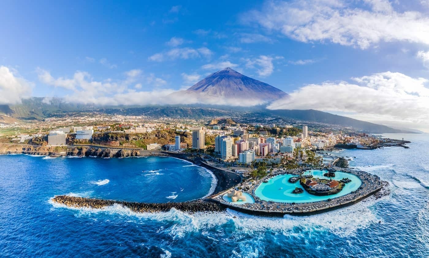 
                                    una vista aérea de una ciudad con un volcán en el fondo