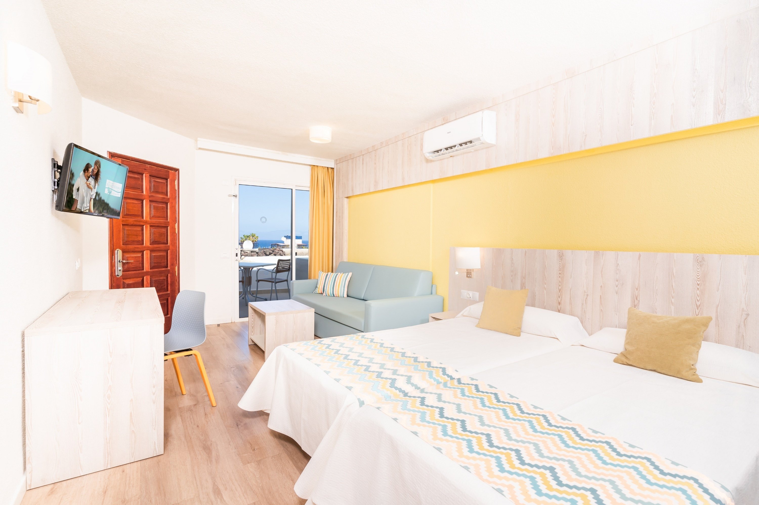 una habitación de hotel con dos camas y un sofá