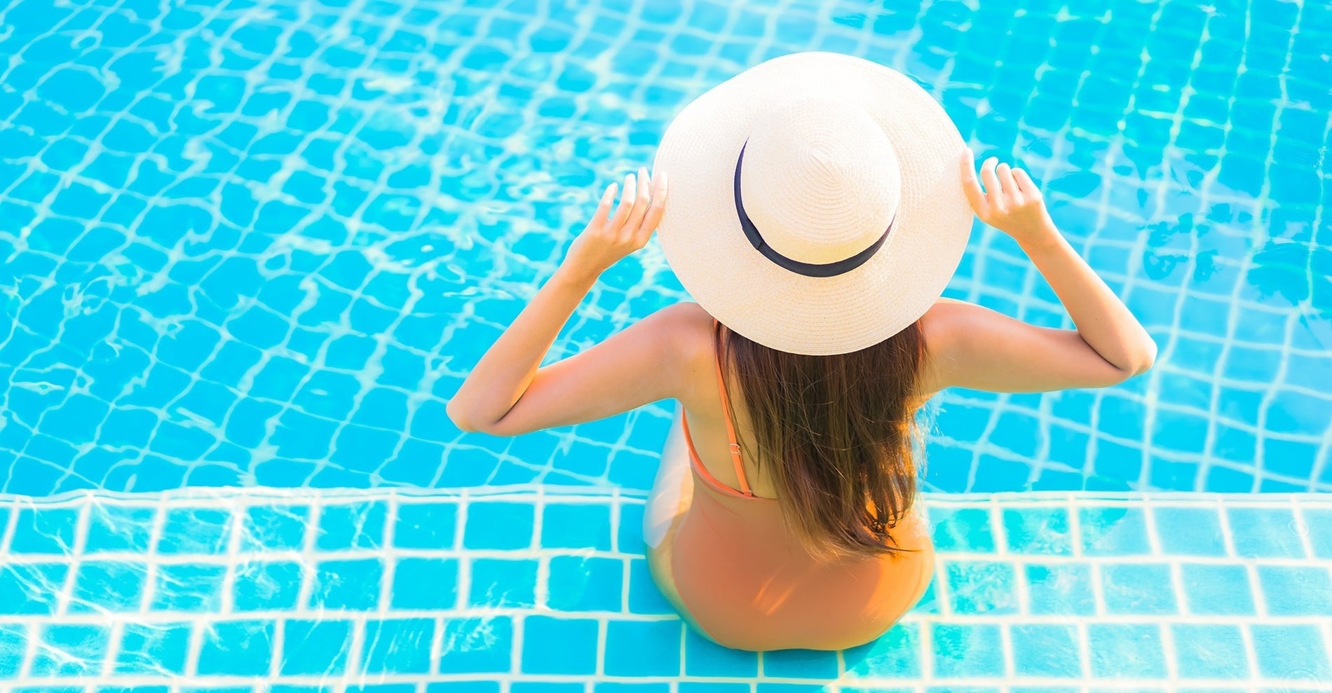 Ein Mädchen sonnt sich am Pool