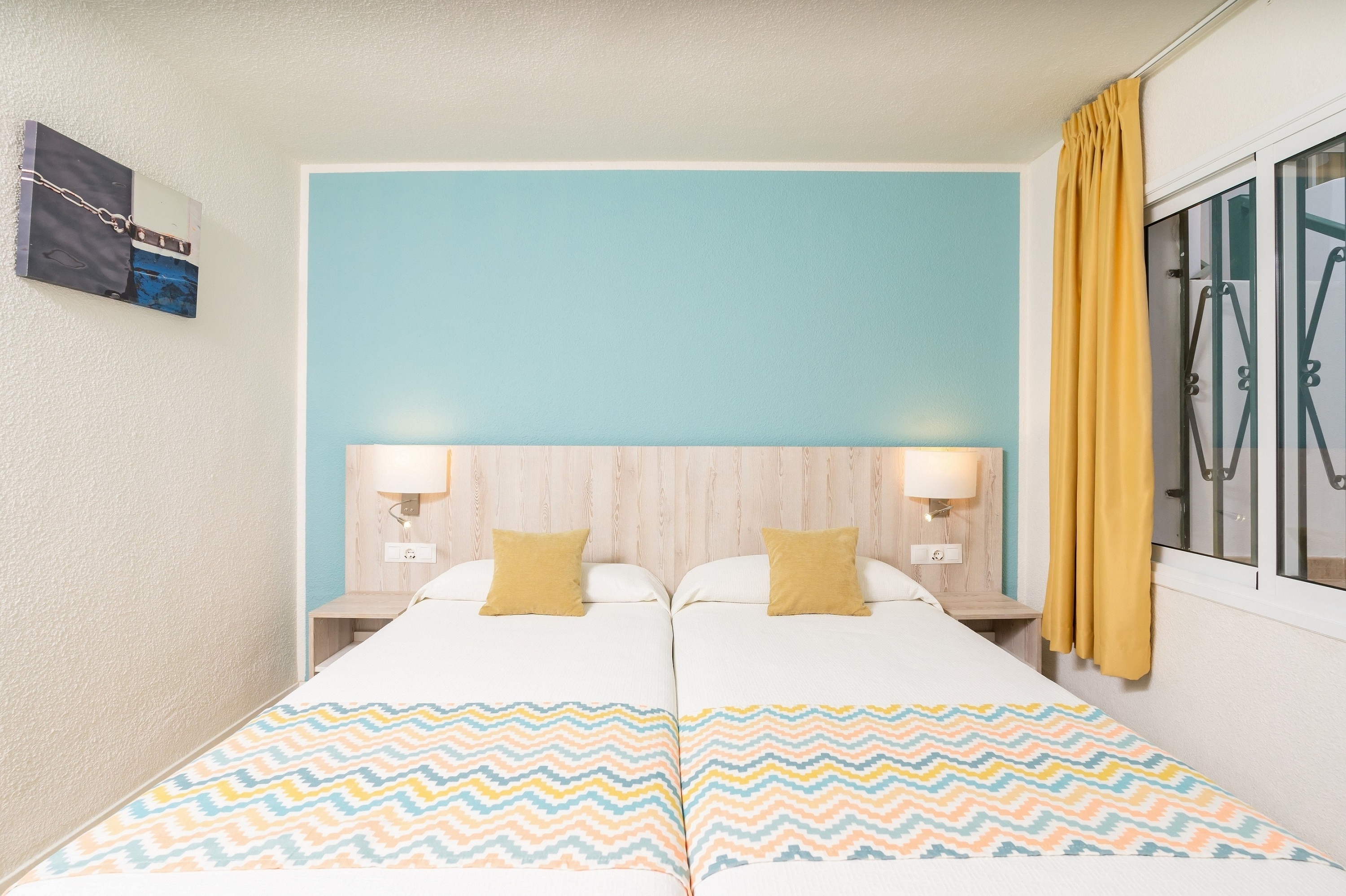 una camera da letto con due letti e una parete blu