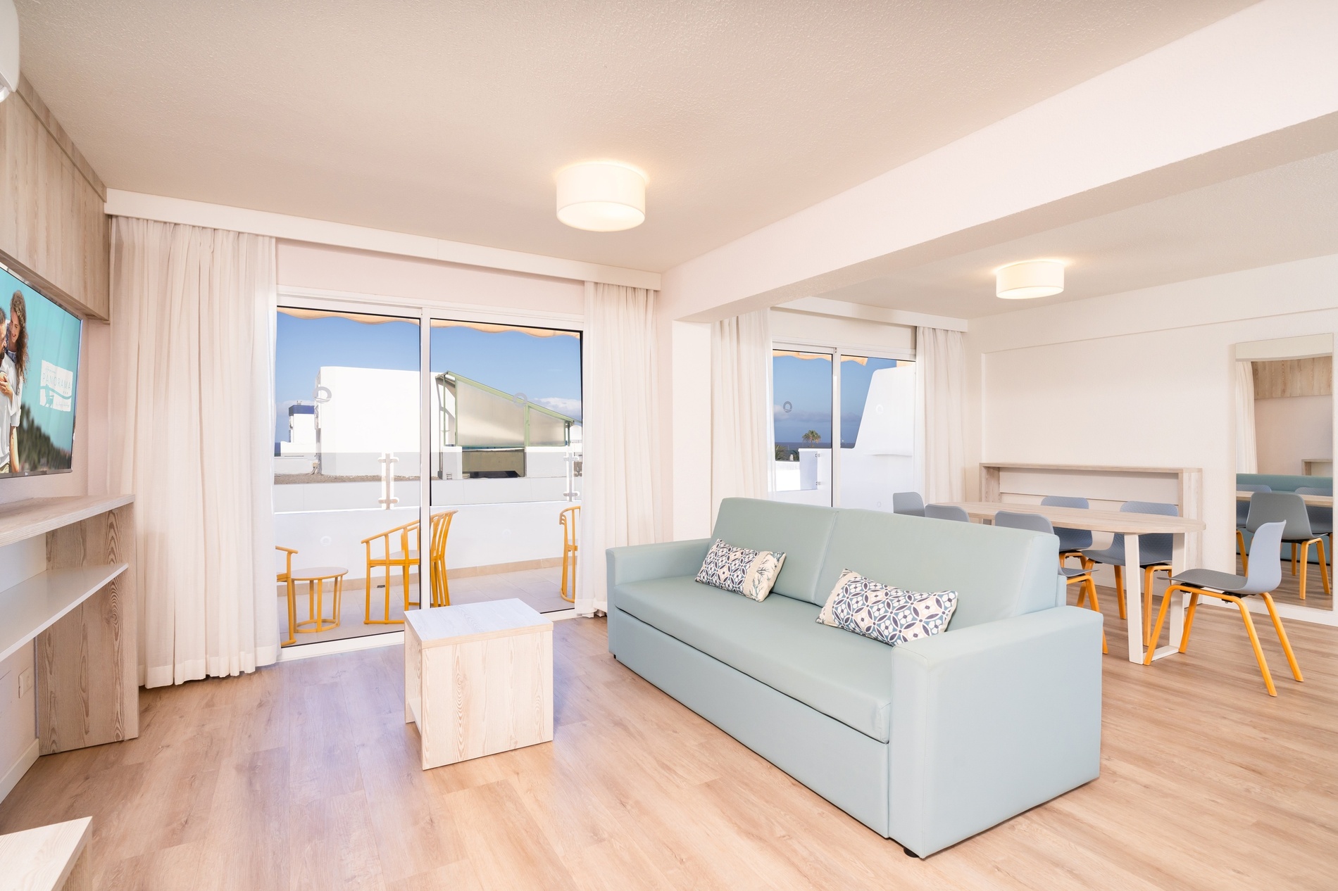 una camera d' albergo con due letti e cuscini colorati