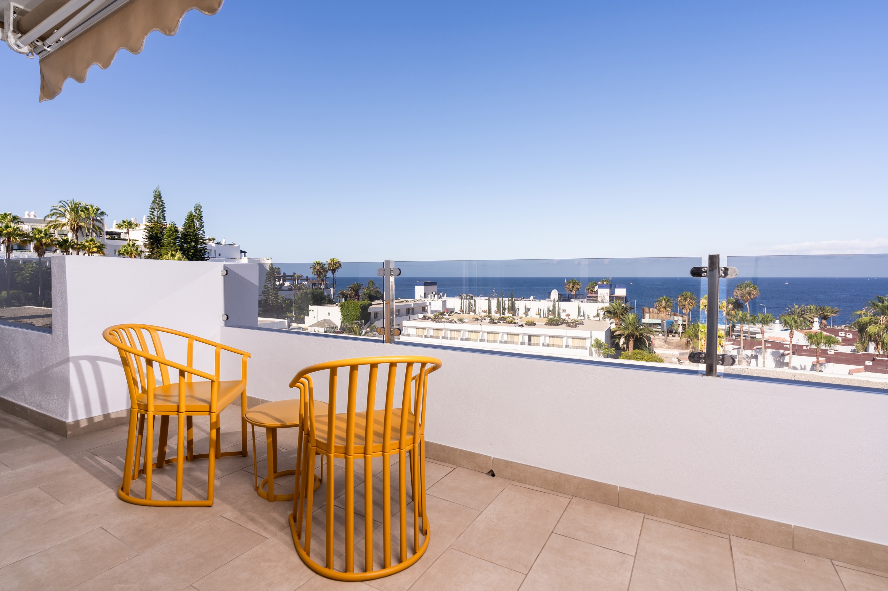 un balcone con due sedie e un tavolo con vista sull'oceano