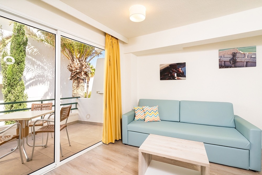 una camera d' albergo con due letti e cuscini colorati