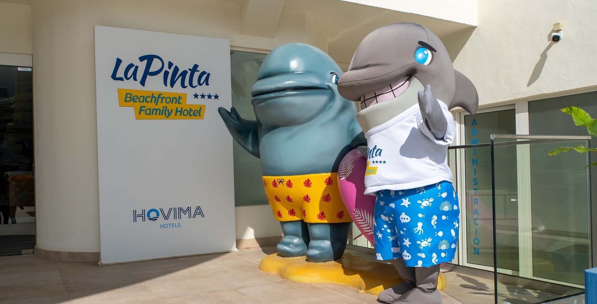 a stuffed dolphin wearing a yellow shirt and blue shorts