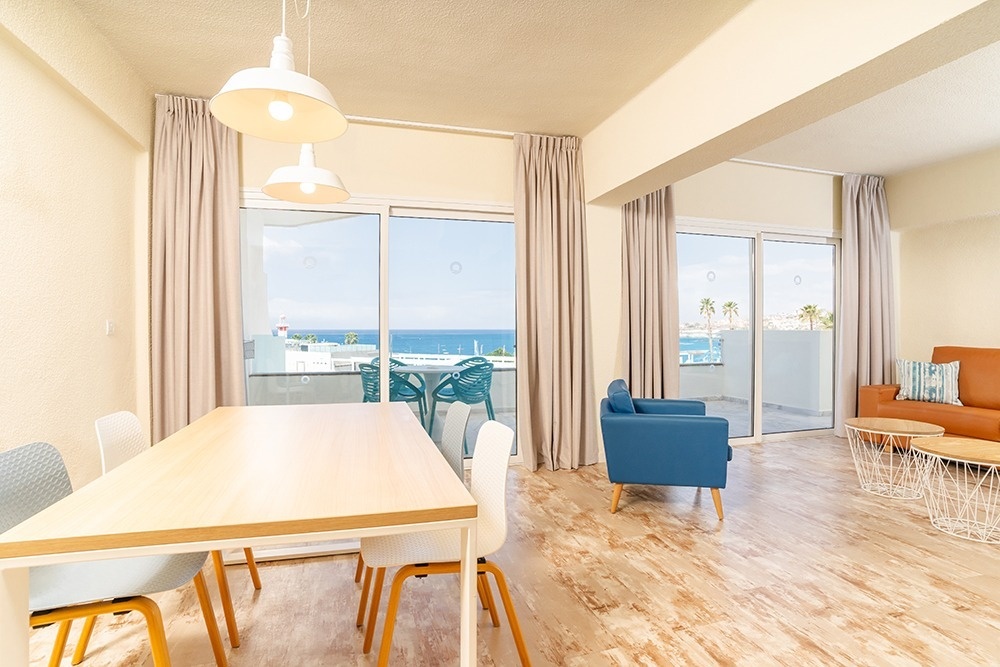 una sala de estar con una mesa y sillas y una televisión