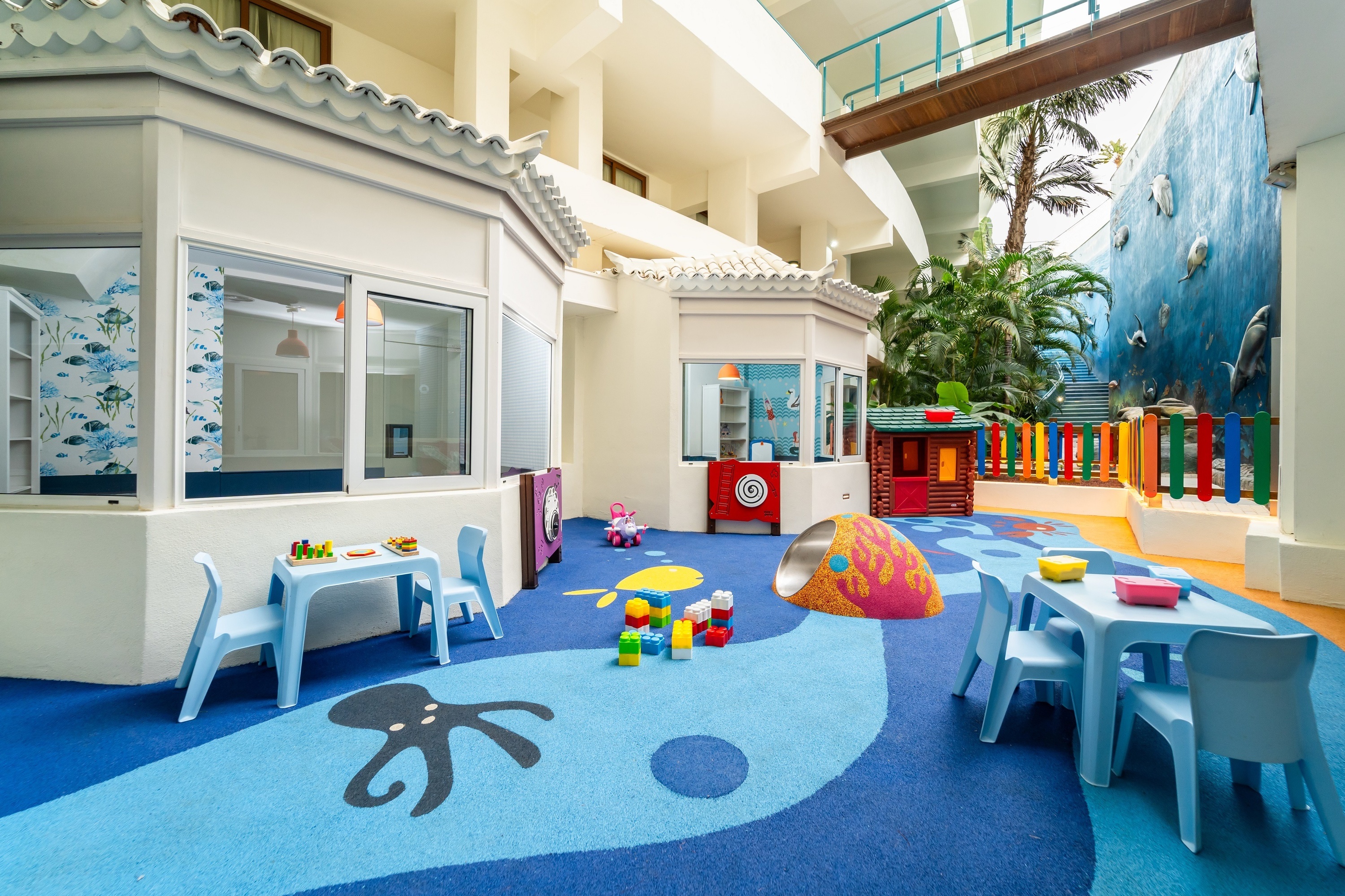 
                                    a child is playing in a room with a table and chairs