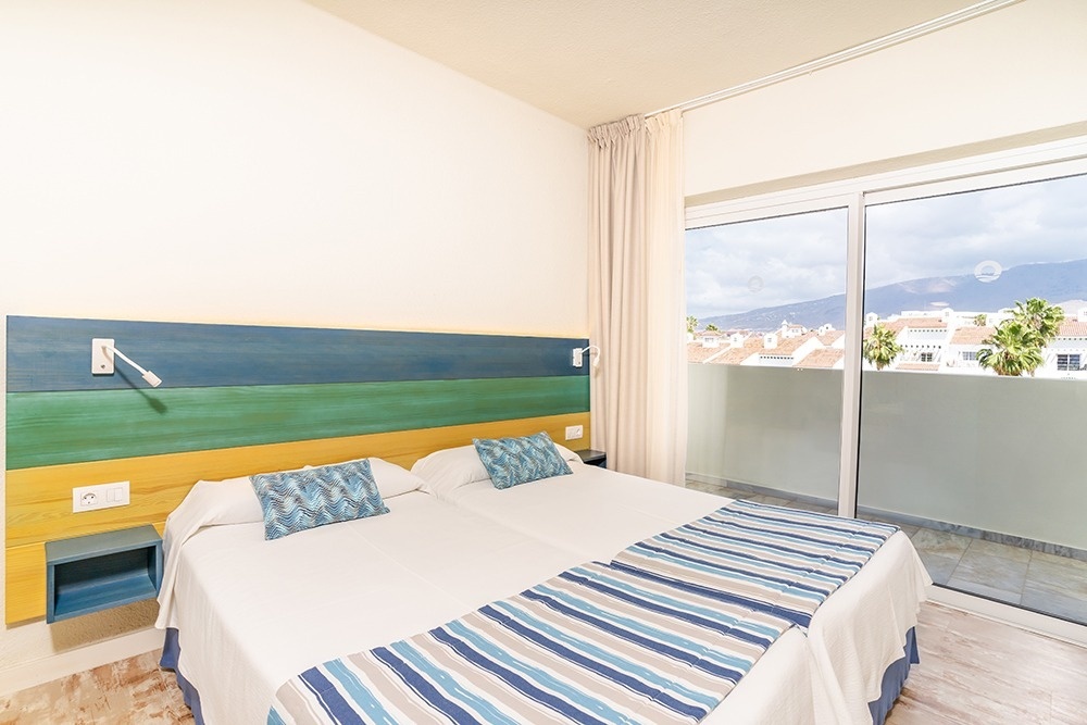 una habitación con dos camas y una gran ventana