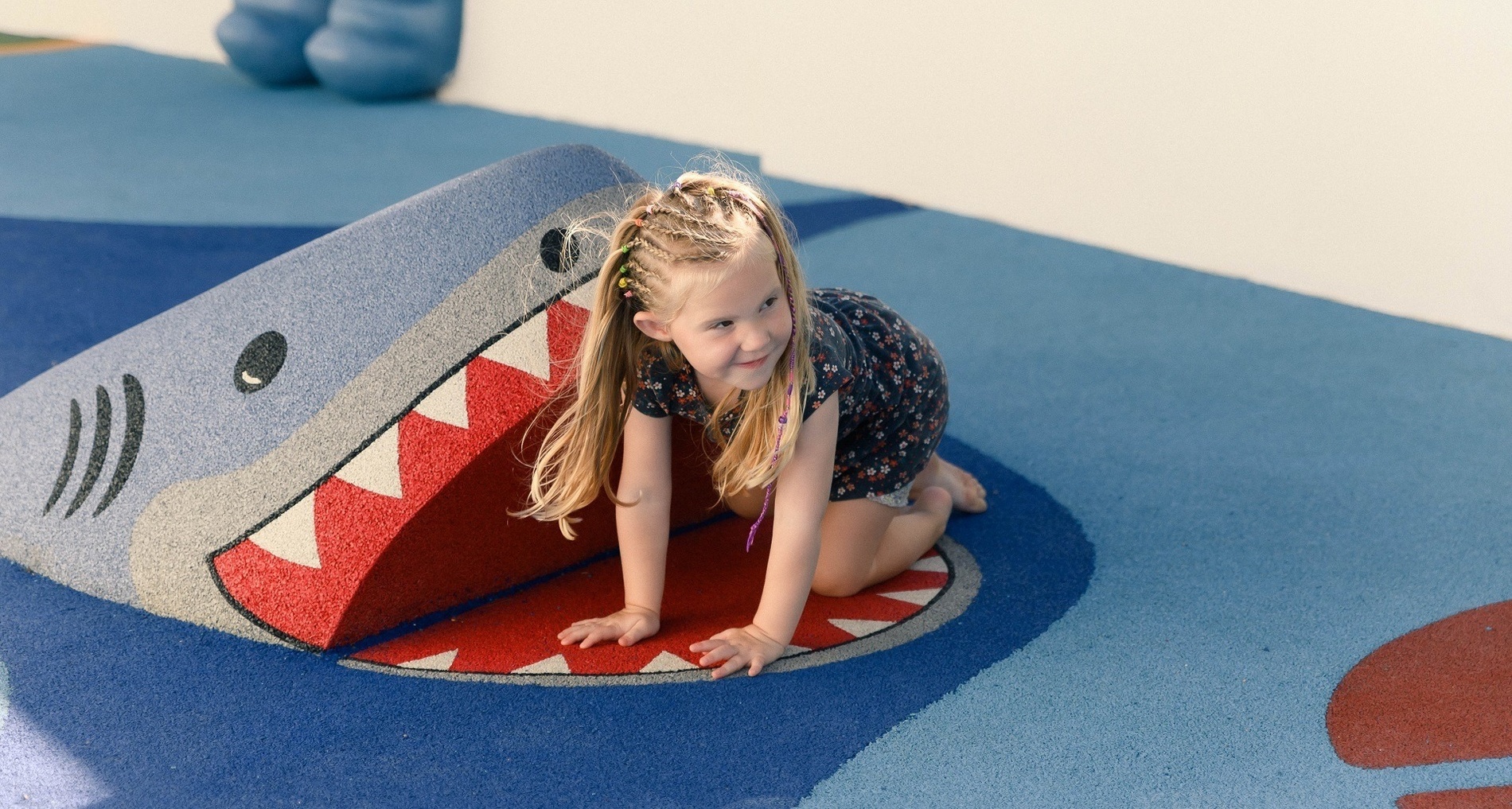 Ein Junge sitzt auf einer Wasserrutsche in einem Pool