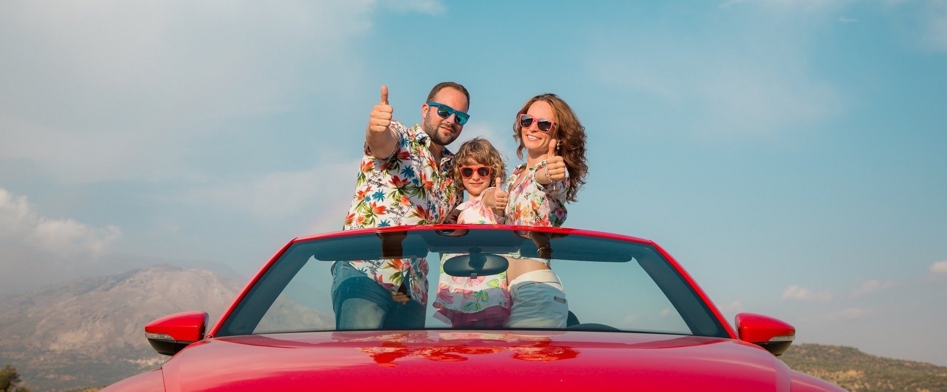 a family sits in the back of a car with an inflatable flamingo