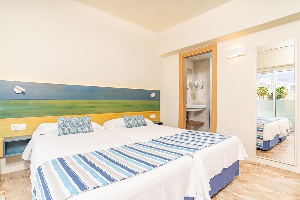 una habitación de hotel con dos camas y un espejo