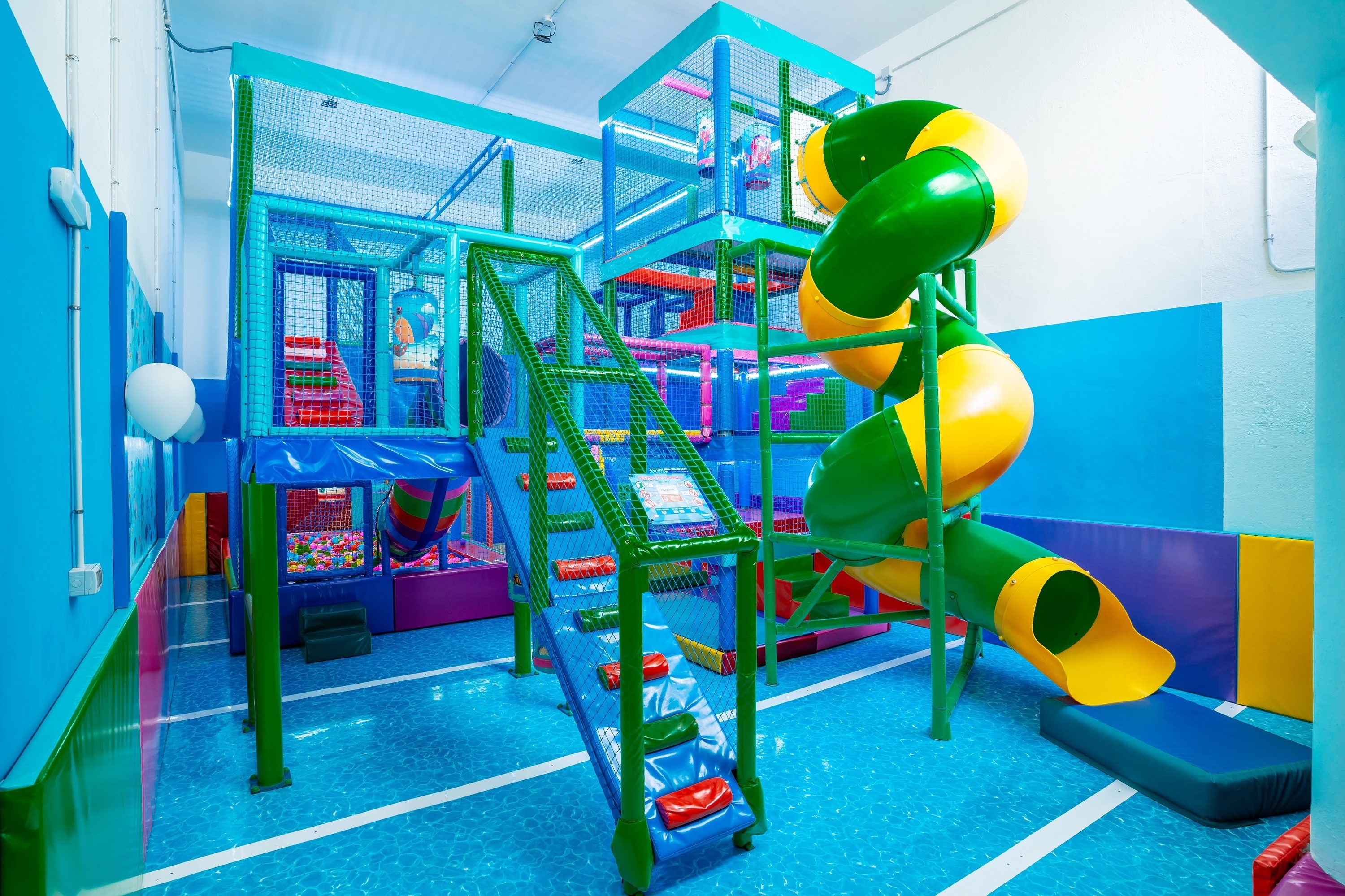 un tobogán verde y amarillo en un área de juegos para niños