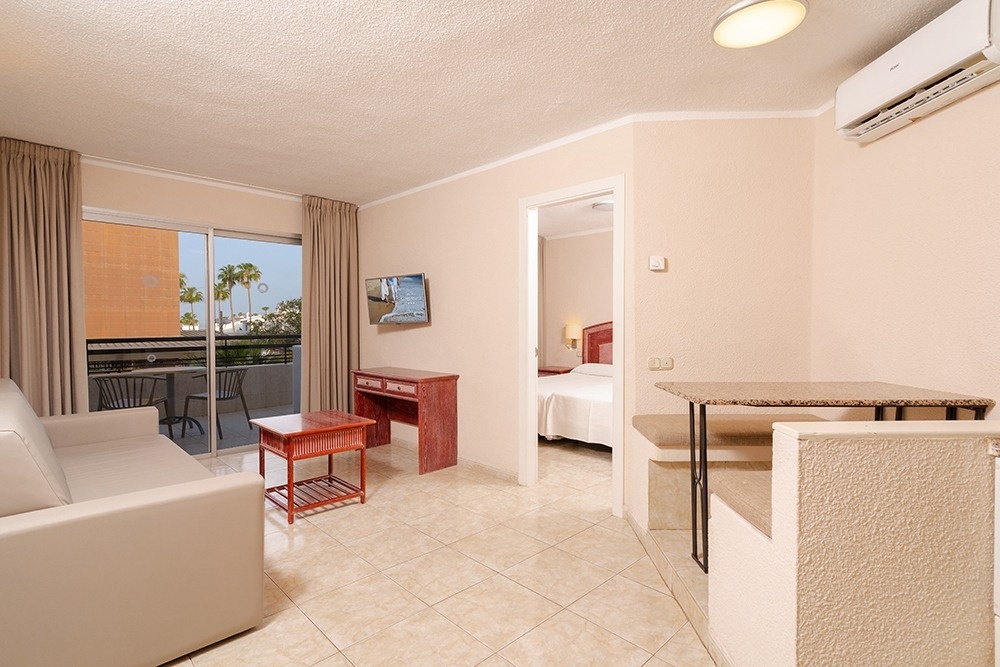 deux chaises et une table sur un balcon avec un arbre en arrière-plan