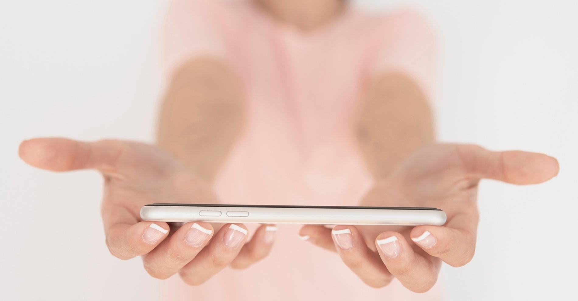 A woman is sitting on a sun lounger looking at the pool.