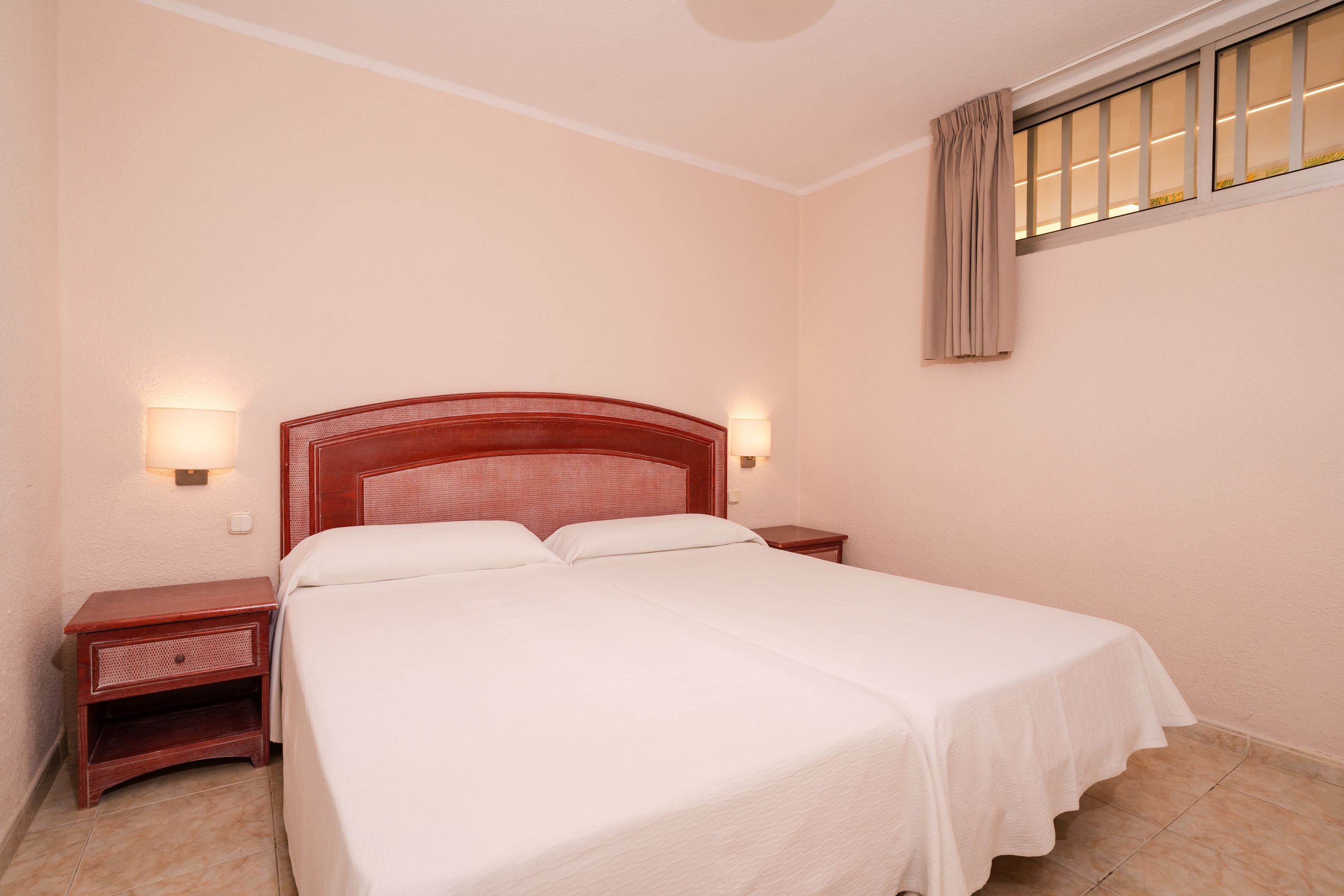 een slaapkamer met twee bedden en een nachtkastje