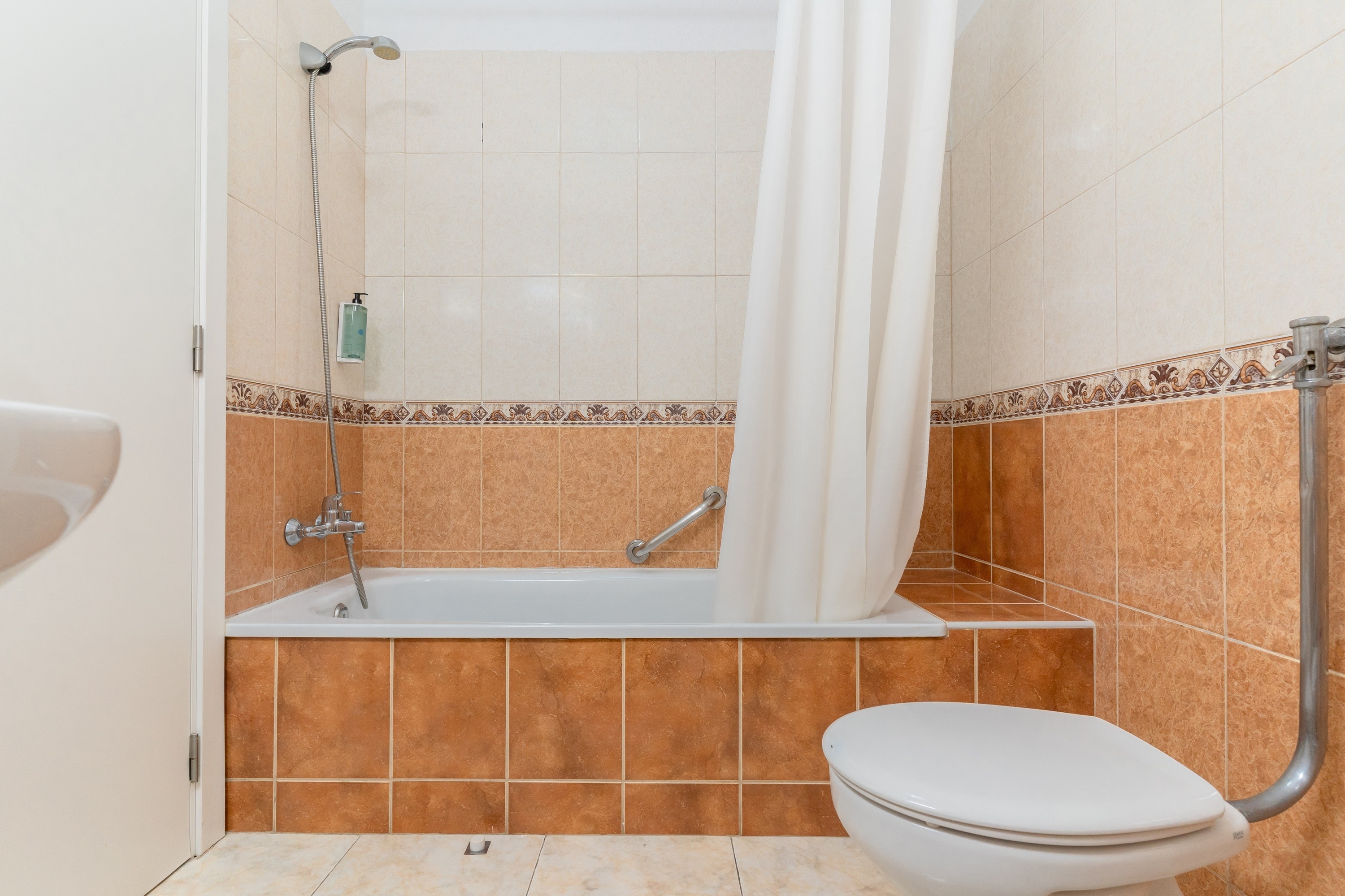 een woonkamer met een televisie en een tafel en stoelen