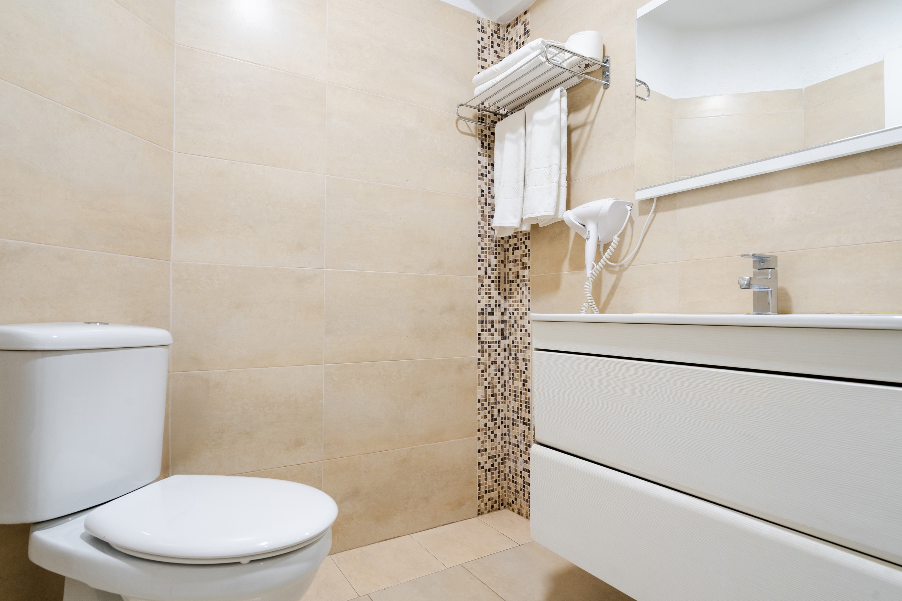 een slaapkamer met twee bedden en een nachtkastje