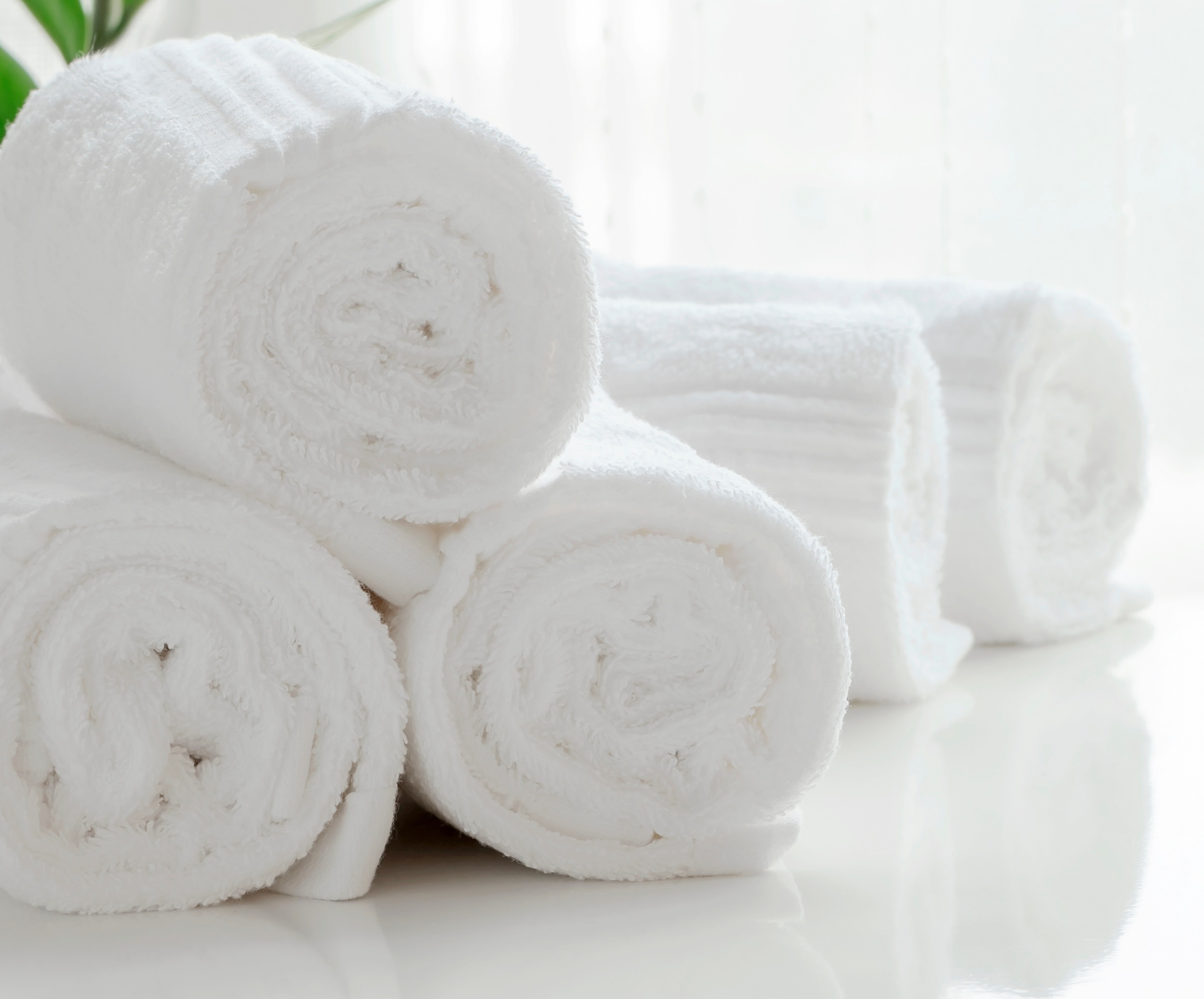tres toallas blancas están apiladas una al lado de la otra