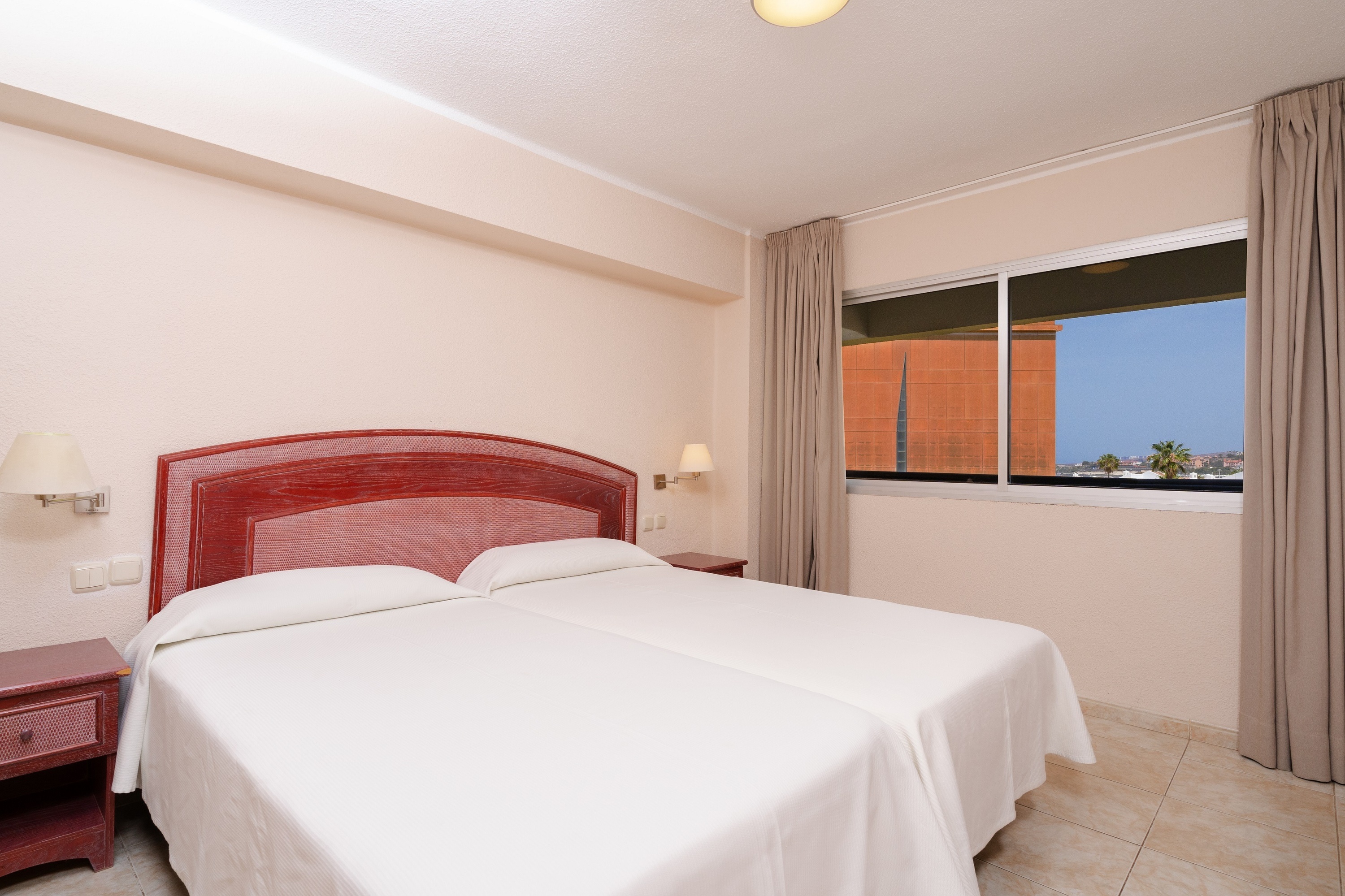 een slaapkamer met twee bedden en een raam