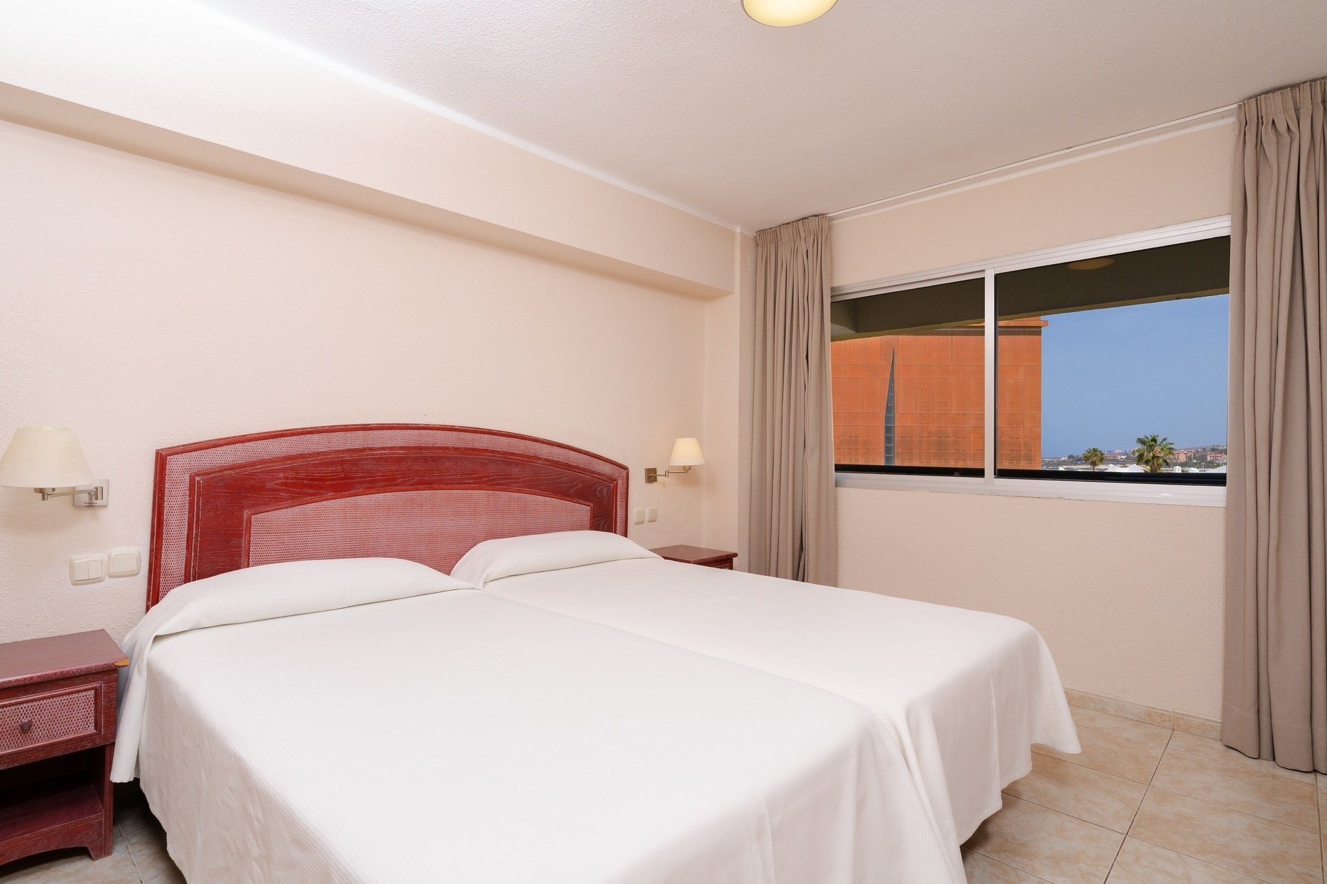 een slaapkamer met twee bedden en een raam