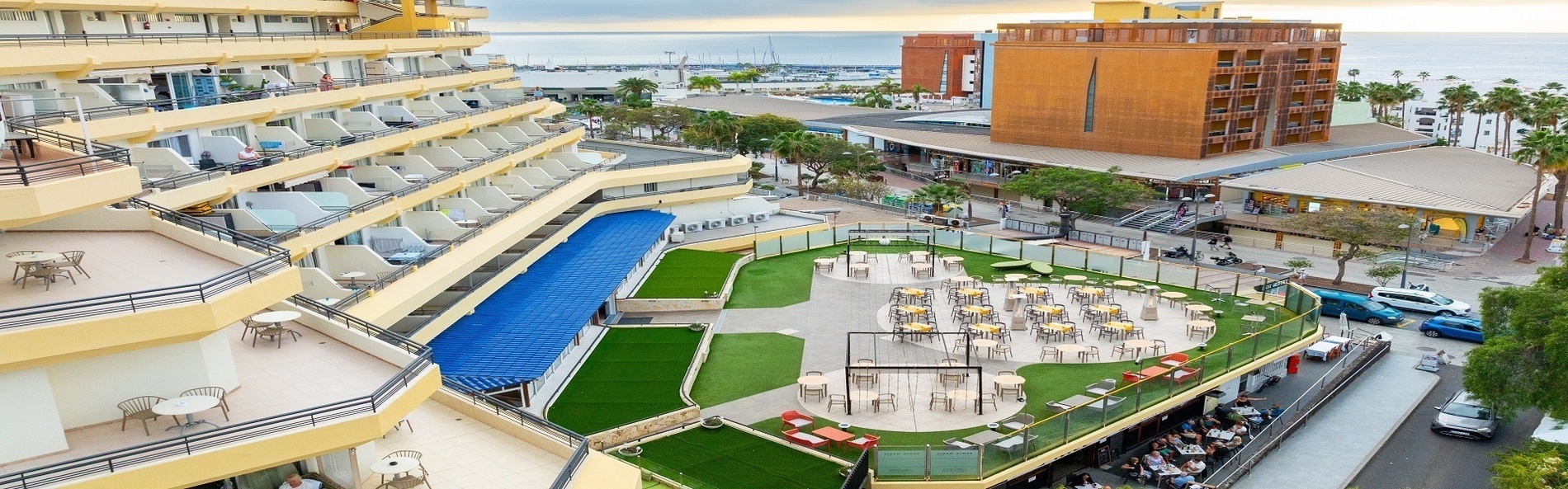 a large swimming pool surrounded by chairs and palm trees