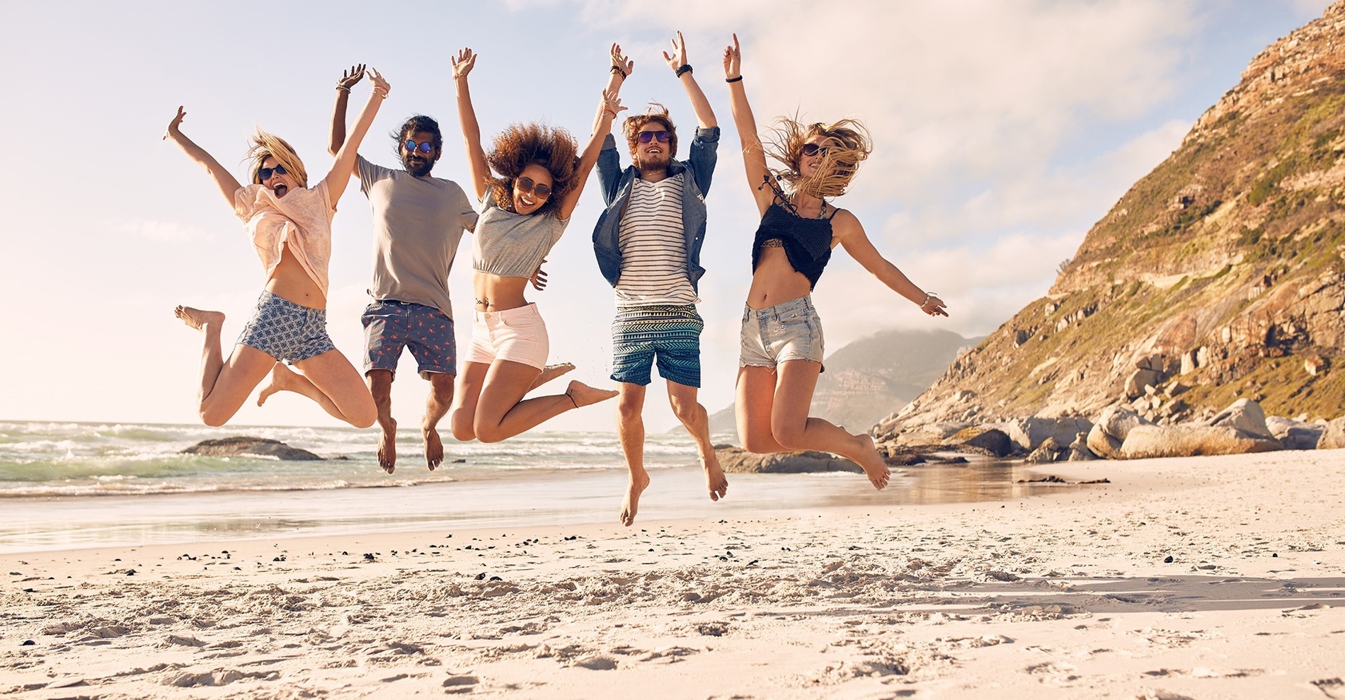 un gruppo di persone che saltano sulla spiaggia