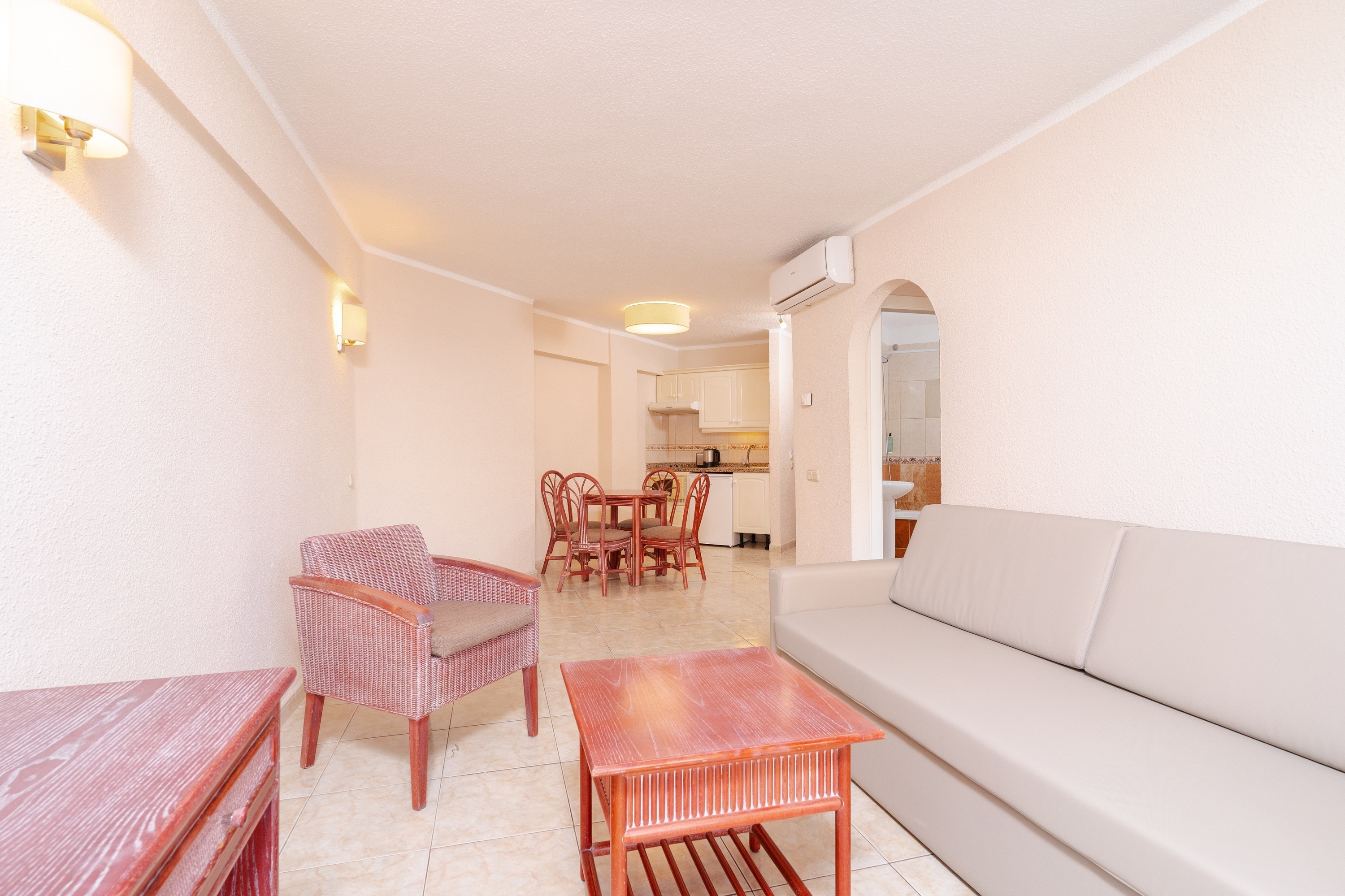 een woonkamer met een bank en stoelen en een televisie