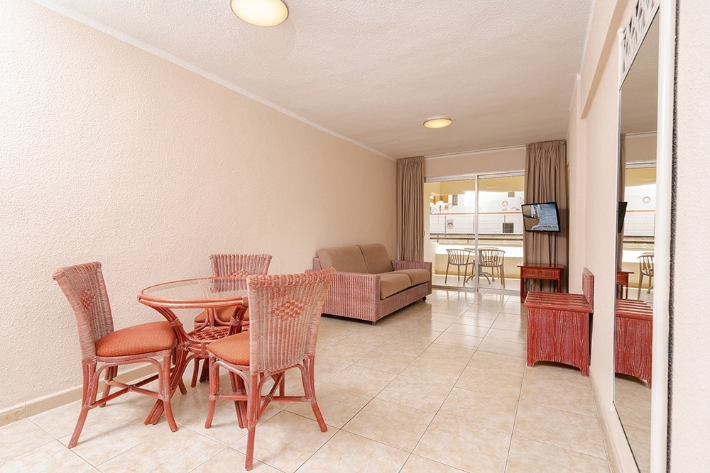 une salle à manger avec une table et des chaises et une télévision