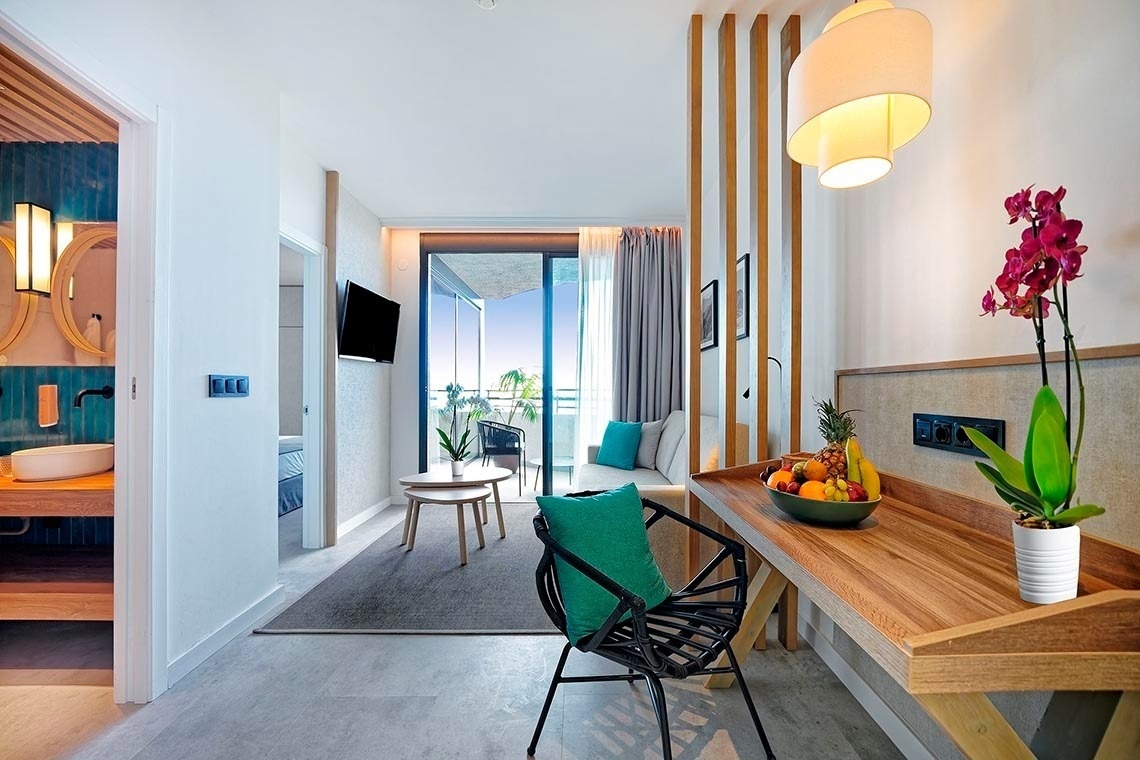 dos sillas y una mesa en un balcón con un árbol en el fondo