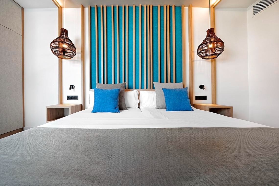 una cama con dos almohadas azules sobre ella