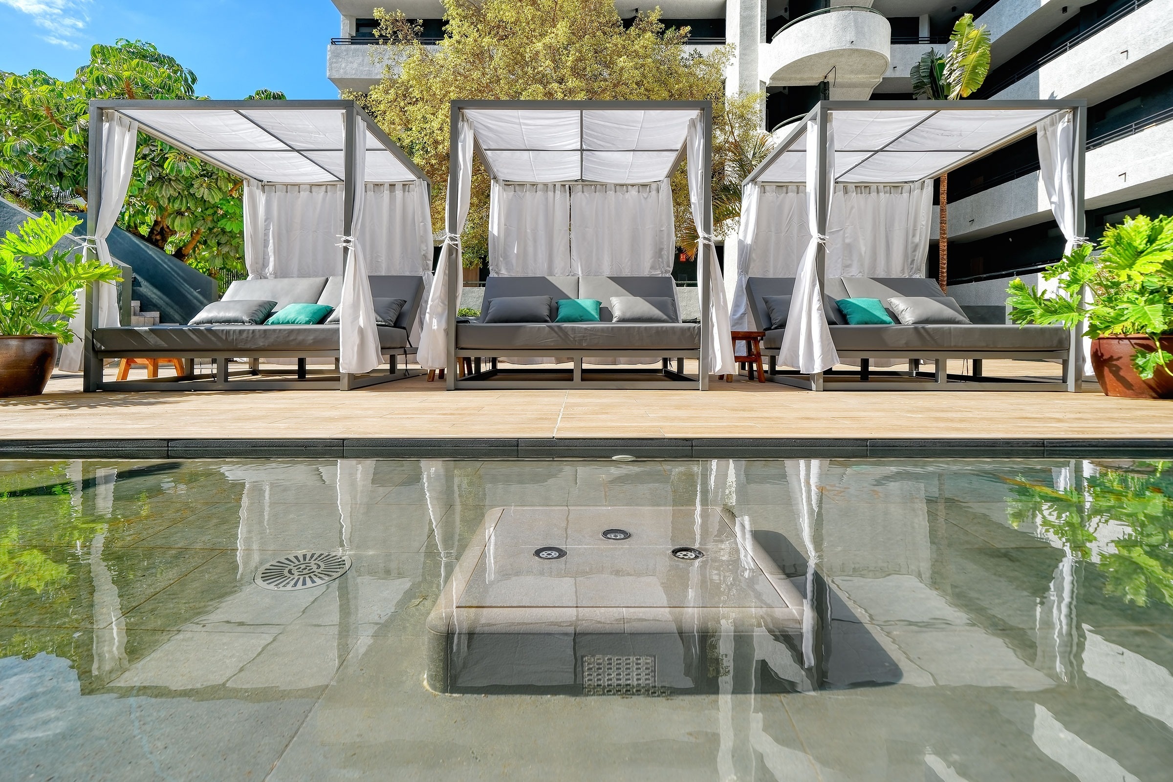 
                                    una piscina rodeada de sillas y sombrillas en un hotel