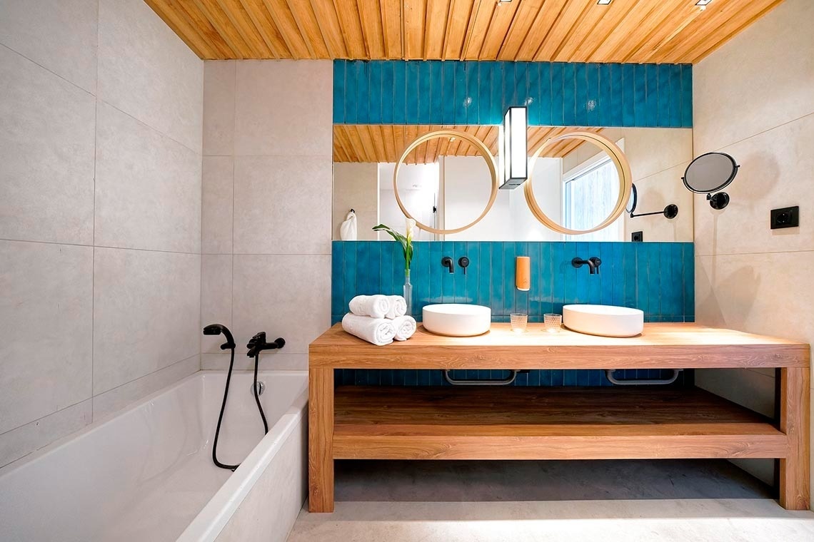 dos sillas y una mesa en un balcón con un árbol en el fondo