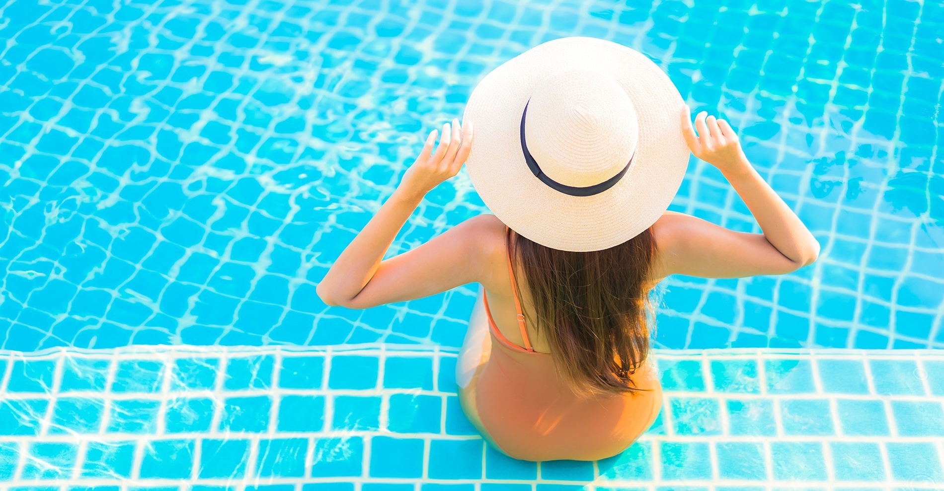 una mujer sentada a borde piscina