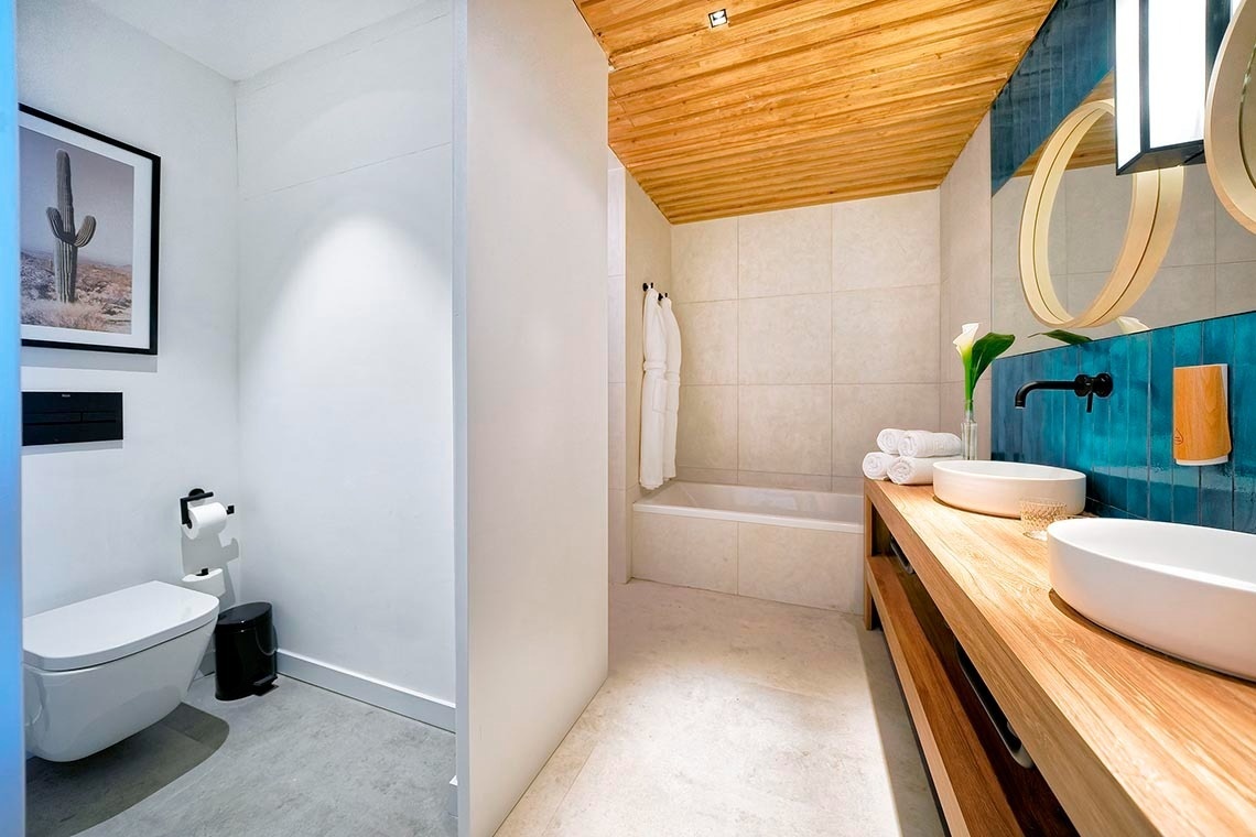 un baño con dos lavabos y un cactus en la pared