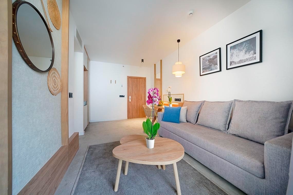 una sala de estar con un sofá y dos mesas de madera