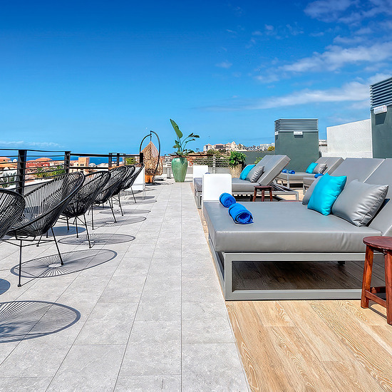Терраса Hovima: Suites Costa Adeje с видом на море и шезлонгами.
