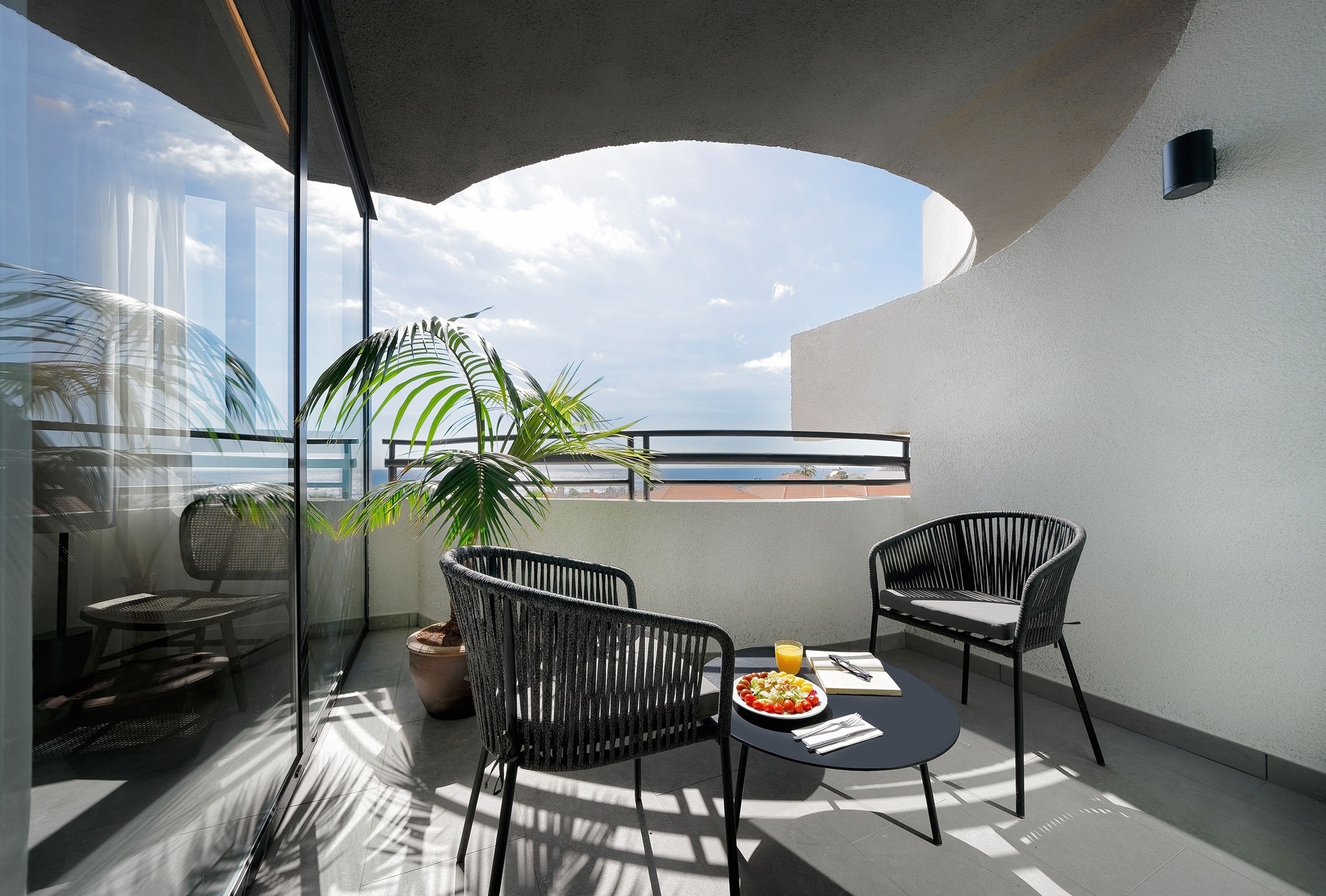 dos sillas y una mesa en un balcón con un árbol en el fondo